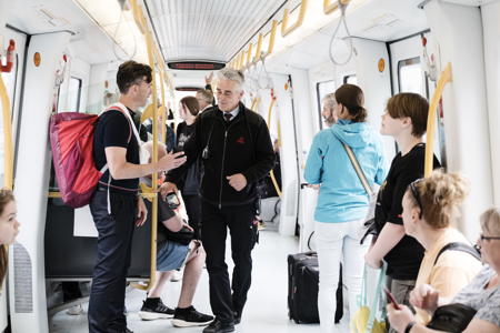 Metrokontrollør interagerer med passagerer